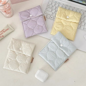 Close-up of quilted cotton storage pouches in pastel colors for small accessories