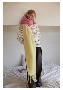 Close-up of soft pink and yellow gradient wool scarf with decorative fringe details