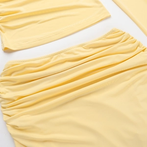 Detail of soft yellow knitted fabric with delicate pleated texture on a two-piece set