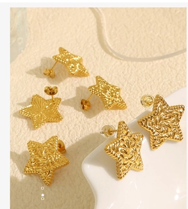 Close-up of golden star stud earrings with sunburst and textured lava finishes