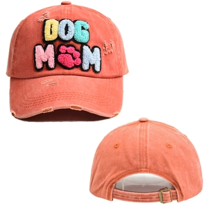 Dettaglio del ricamo DOG MOM sul berretto da baseball arancione corallo effetto lavato