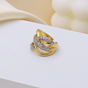 X-shaped gold ring with twisted stripes and zircon inlay on a white platform