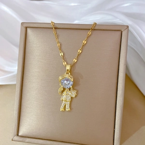 Detail of gold titanium girl pendant with sparkling cubic zirconia on a silk background
