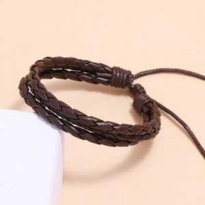 Gros plan d'un bracelet en cuir tressé marron foncé avec cordon de serrage réglable