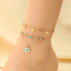 Détail de la chevillère dorée à plusieurs rangs avec charms œil bleu et un pendentif