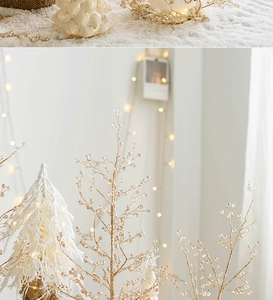 Detailopname van gouden kralenslingers en een besneeuwde mini kerstboom decoratie set