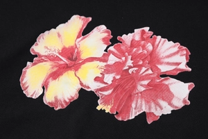 Gros plan détaillé d'un imprimé floral rouge et jaune vif sur un tissu en coton noir