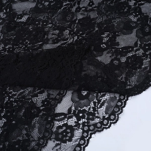 Close-up of black lace fabric showing intricate floral patterns and fine mesh texture