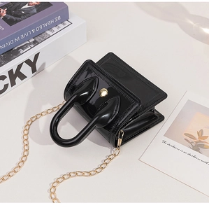 Top view of a black jelly mini handbag with curved handle and gold chain strap