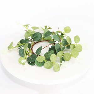 Close-up of green eucalyptus wreath with white berries on a white decorative plate