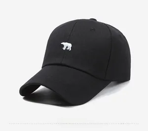 Detailed embroidery of a white polar bear on a premium black cotton baseball cap surface