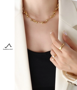 Detail view of gold stainless steel thick chain necklace and pearl ring set for women