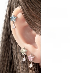 Close-up of star-shaped zircon earrings with water drop pendants in various colors