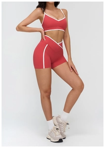 Detail of red sports bra and high-waisted shorts with white contrast trim for fitness