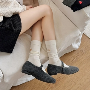 Detail of cream mid-calf socks with brown follow your heart embroidery on the cuff