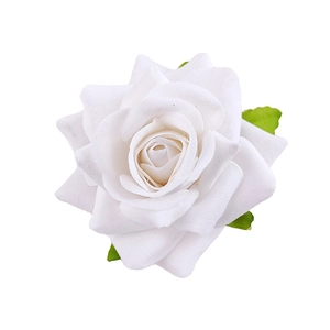 Detailed view of handmade white fabric rose with green leaves for floral hair accessories