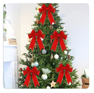 Close-up of five red Christmas bows with gold edges decorating a festive tree at home