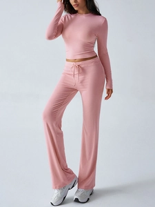 Detail of pink long-sleeve crop top and high-waisted wide-leg yoga pants set