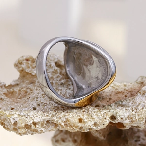 Vue détaillée d'une bague torsadée bicolore en argent et or 18 carats sur pierre de corail