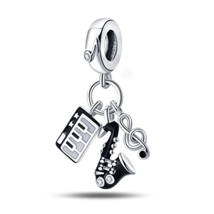 Detail of silver music charms featuring piano keyboard, saxophone and treble clef designs
