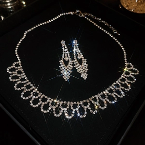 Close-up of sparkling rhinestone waterdrop tassel necklace and earrings set in a gift box