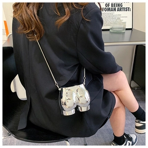 Artistic silver chrome body-shaped crossbody bag with a sleek metallic chain strap