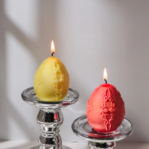 Macro view of Easter egg candles with intricate baroque relief on silver holders