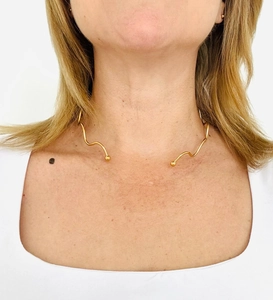 Detail of 18K gold plated stainless steel wave choker with round ball ends on model