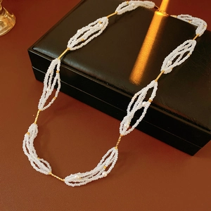 Primer plano de un collar de perlas de varias capas con detalles dorados sobre cuero