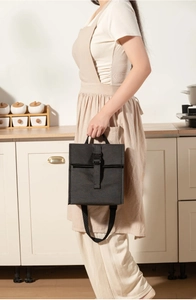 Close-up of black insulated lunch bag with buckle closure and adjustable strap
