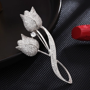 Detailed close-up of tulip brooch with white cubic zirconia pavé on a black tray