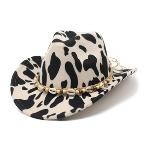 Cow print felt fedora hat with wide brim featuring a seashell and wood bead decorative band