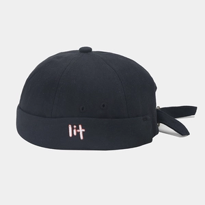 Detalle del gorro miki negro que muestra el bordado lit y la textura de lona