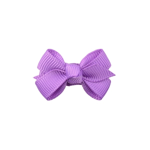 Gros plan sur la texture du ruban gros-grain violet et le nœud symétrique de la barrette