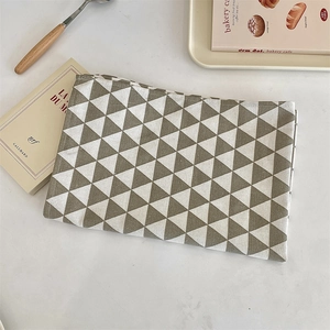 Détail de set de table en tissu avec motif géométrique marron et couture soignée