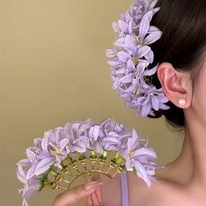 Detailed view of elegant purple fabric lily flower hair fork for women's hair styling