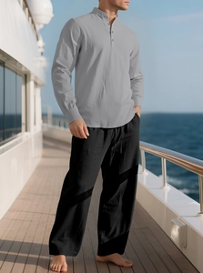 Men's casual linen set with grey stand-collar shirt and black wide trousers on boat