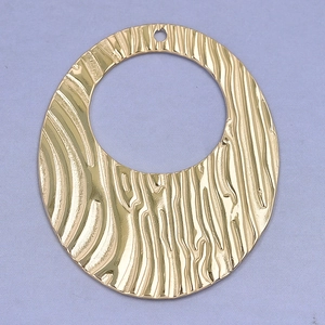 Detailed view of a gold circular stainless steel pendant with irregular hammered texture