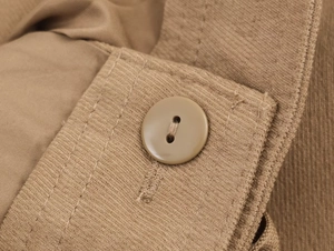 Vue macro détaillée de la texture du velours côtelé kaki avec des boutons en résine