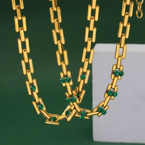 Detail of gold punk hip-hop chain necklace with green zircon stones on geometric props