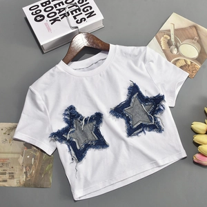 Detail of white crop top featuring denim star patches with raw fringe edges
