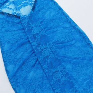 Dettaglio del tessuto in pizzo blu con motivi floreali all'uncinetto per un vestito