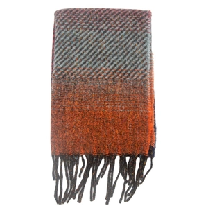 Detail of grey and orange gradient scarf featuring fringe trim and knit texture