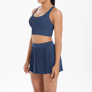 Detail of navy blue high-waist pleated tennis skirt and cross-back sports bra set