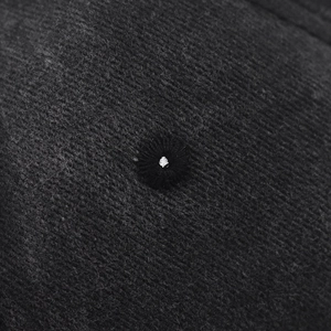 Macro shot of washed corduroy fabric detail and embroidered eyelet on baseball cap