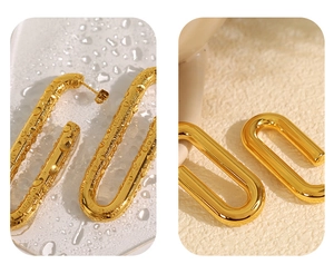 Nahaufnahme goldener U-förmiger Titanohrringe mit Wassertropfen für wasserfeste Qualität