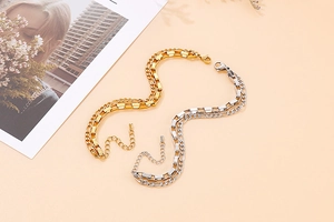 Macro view of two-layer gold and silver stainless steel chain bracelet on warm background