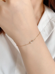Close-up of a 14k gold plated S925 silver bracelet with sparkling zircon hearts on a wrist