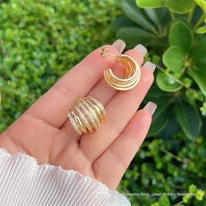 Vue détaillée de boucles d'oreilles multicouches plaquées or 18 carats avec zircons