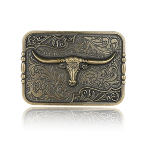 Vintage bronze western cowboy belt buckle with embossed longhorn bull and floral patterns